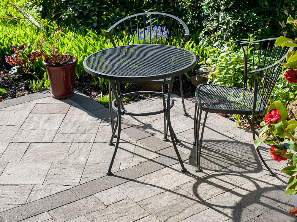 Full patio renovation with flat paving stones and patio furniture in Portland, Oregon