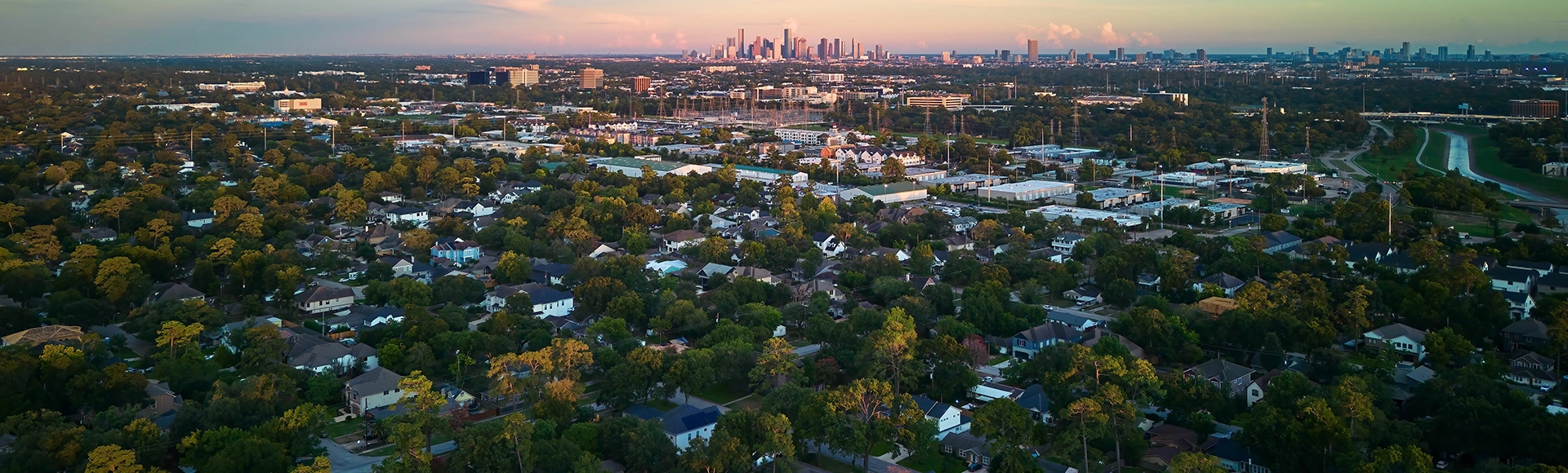 Horizontal aerial view of Houston, Texas skyline from a suburban neighborhood under blue sky