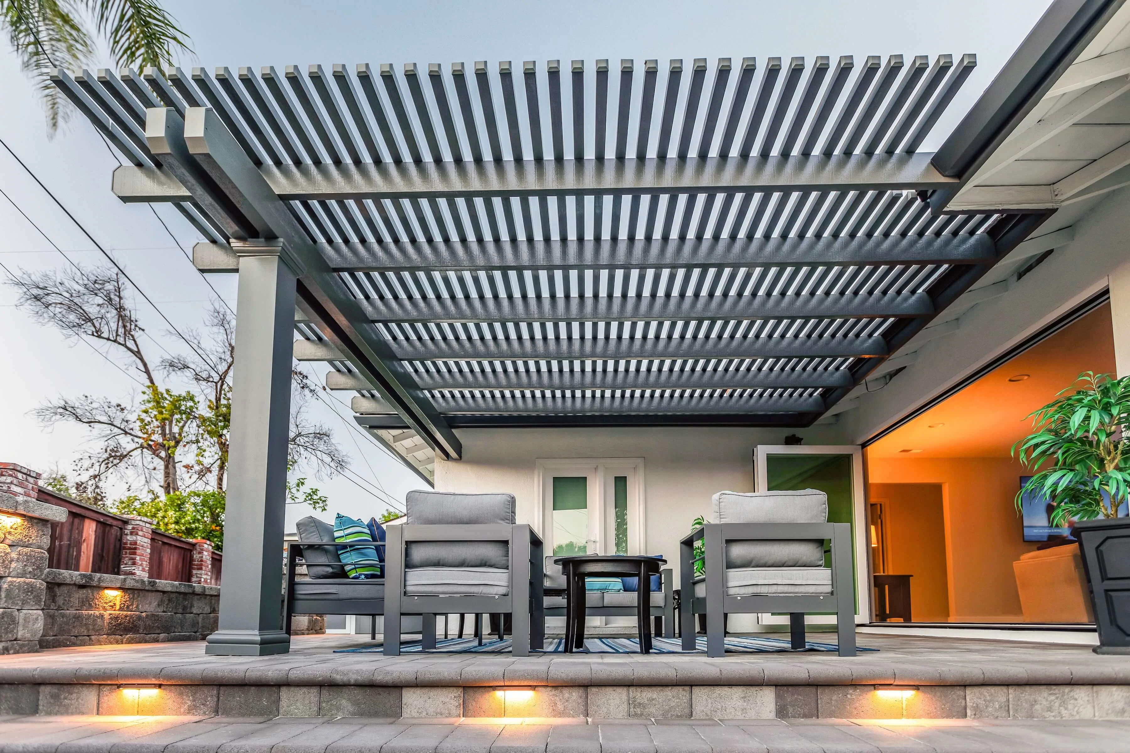 Modern pergola over paver patio with built-in step lighting 