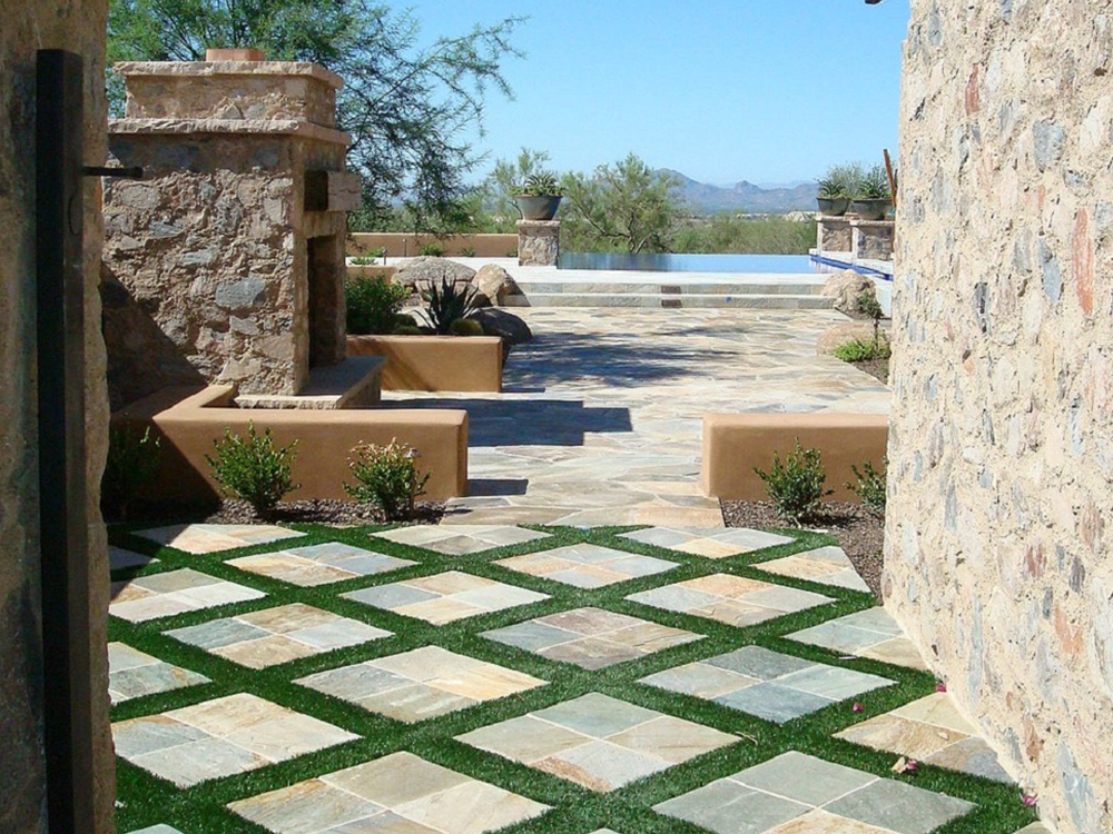 Side Patio in the desert outside Vegas with paving stones, artificial turf, paver walls, pool and fire place. 