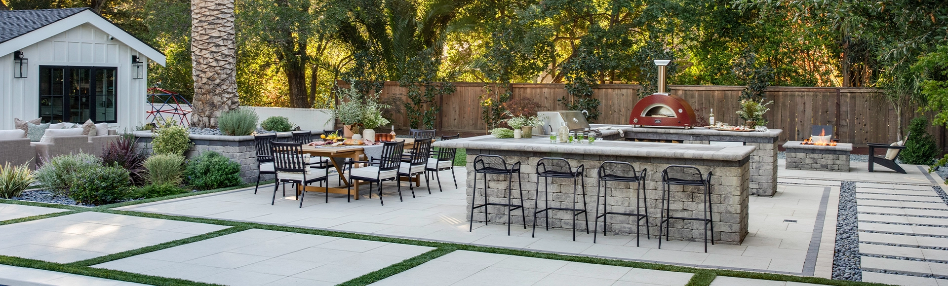 Paving stones transform an ordinary yard into an oasis with built-in fire pit, turf and patios. 