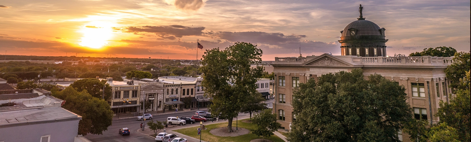 Architecture of Courthouse in Georgetown, Texas with street view, cars, greenery at sunset