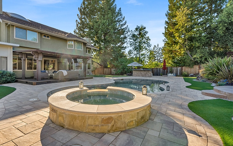 Large backyard renovation by System Pavers with pool, pavers, turf and pergola. 