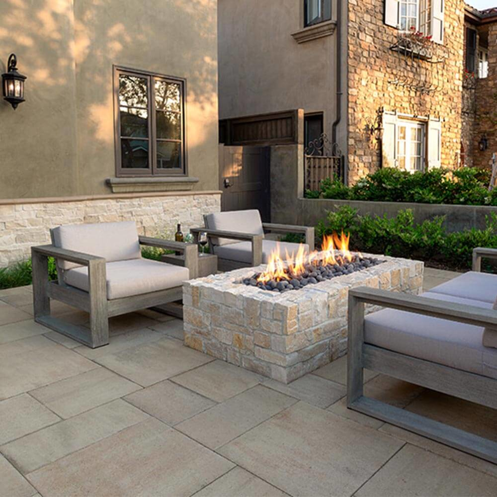 stone fire pit on pavers in a backyard