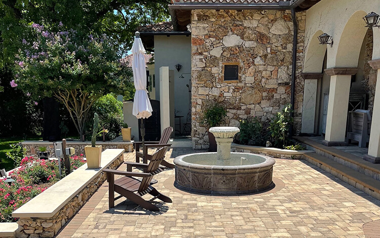 Texas paving stone patio with stone water fountain and paving stone wall and stairs
