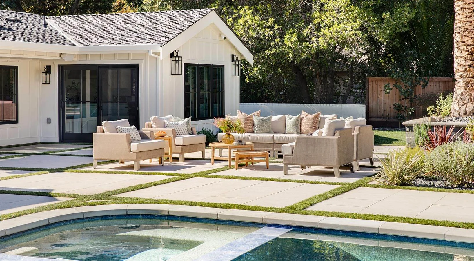 Paving stone patio by a pool with artificial grass in-lays