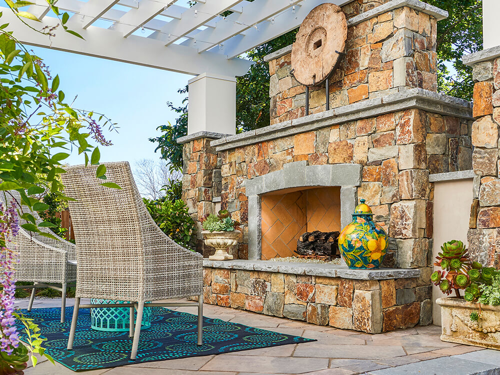 Outdoor fire place made of stone in California with pergola