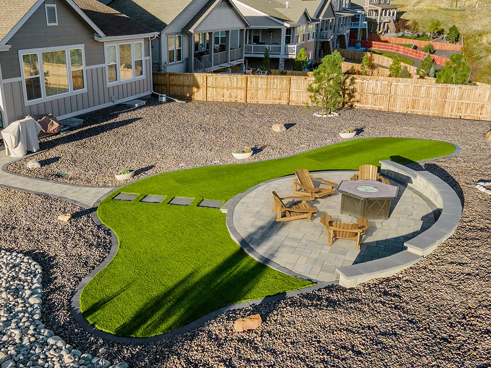 Large artificial turf inset with paving stone fire pit in Colorado. 