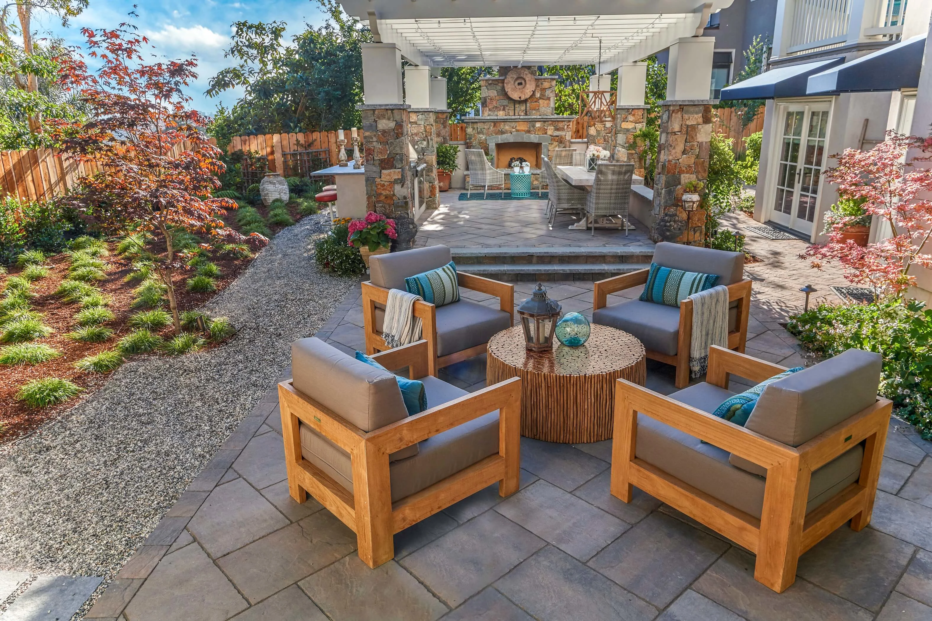Stunning outdoor fireplace and pergola-covered kitchen with plenty of outdoor seating