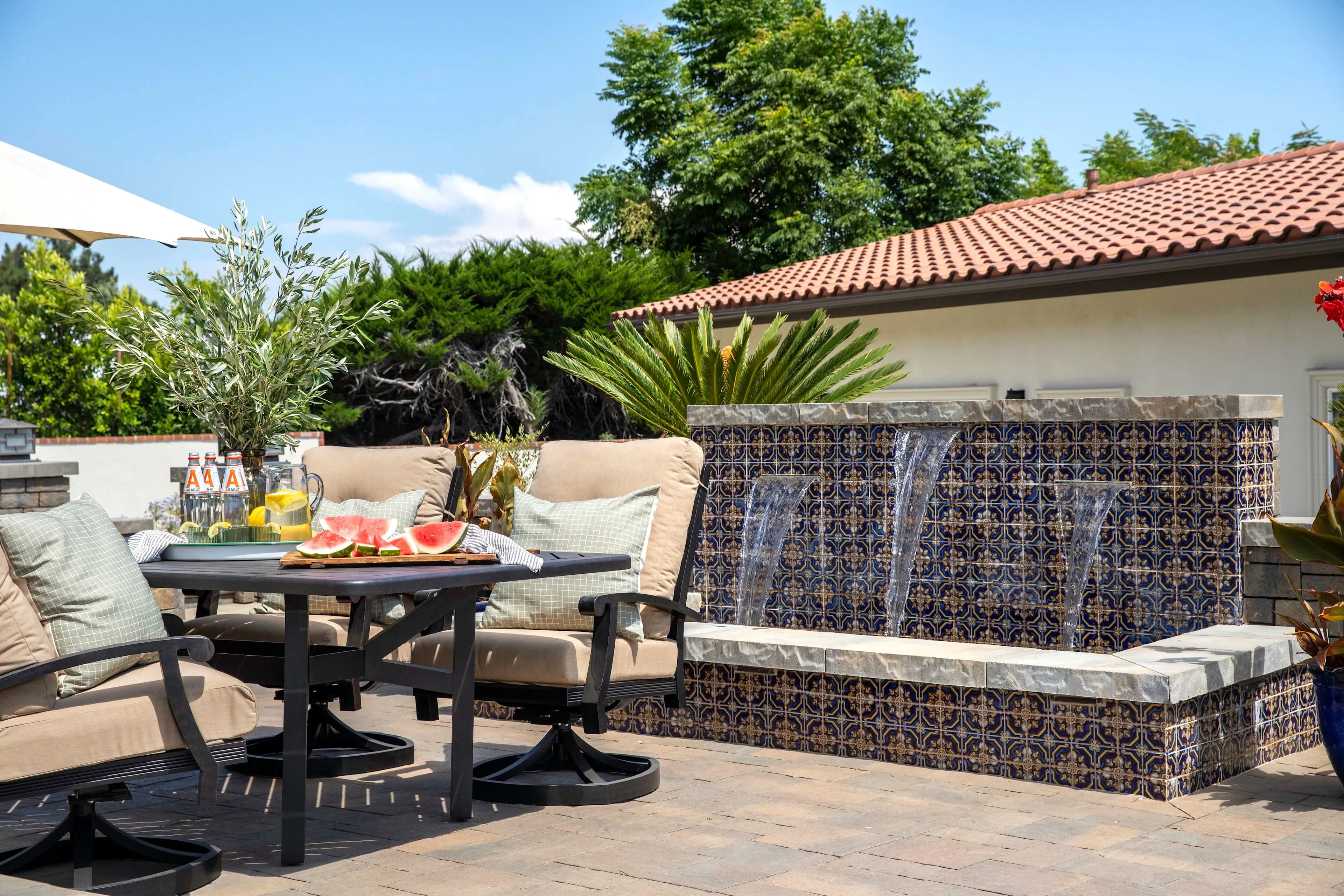 Tile water fountain and outdoor dining on paver patio in SoCal backyard 