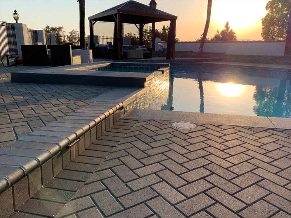 Southern California paving stone pool deck at sunset with pegola