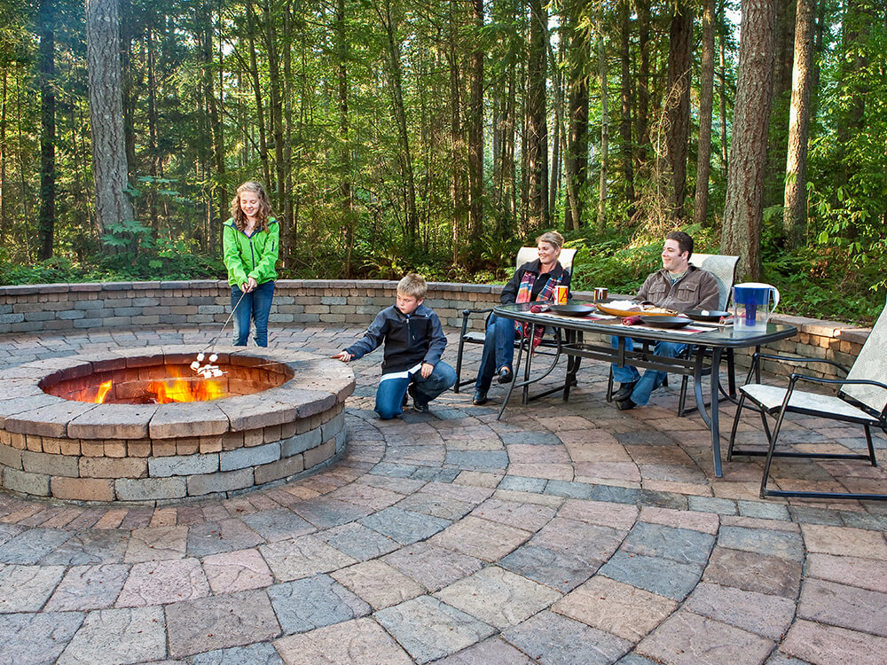 Family gathered around a stone fire pit in PNW