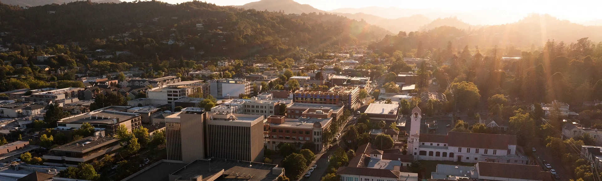 Sunset light shines on the historic Spanish Colonial mission and downtown skyline of San Rafael, California, USA.