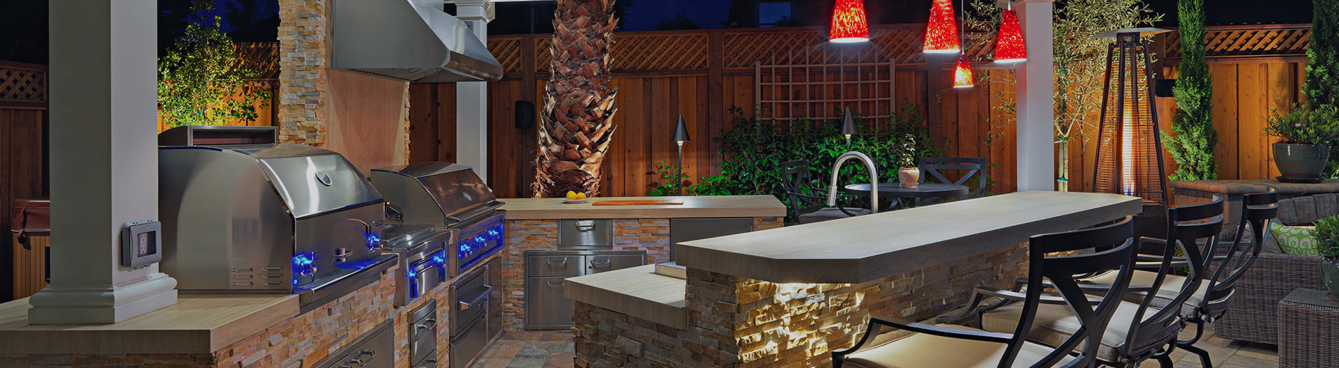 Outdoor kitchen with built-in bar, grill, sink and lighting. 