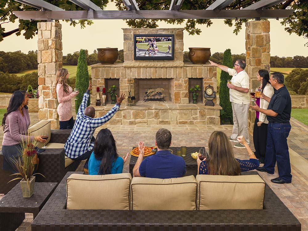Outdoor fireplace, group, party, cheering, game day, pillars, chimney, mantle, outdoor tv, patio furniture, outdoor living room, paving stones, universal region, daytime
