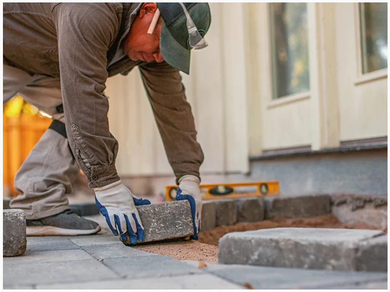 System Pavers employee installing pavers onto a patio. 