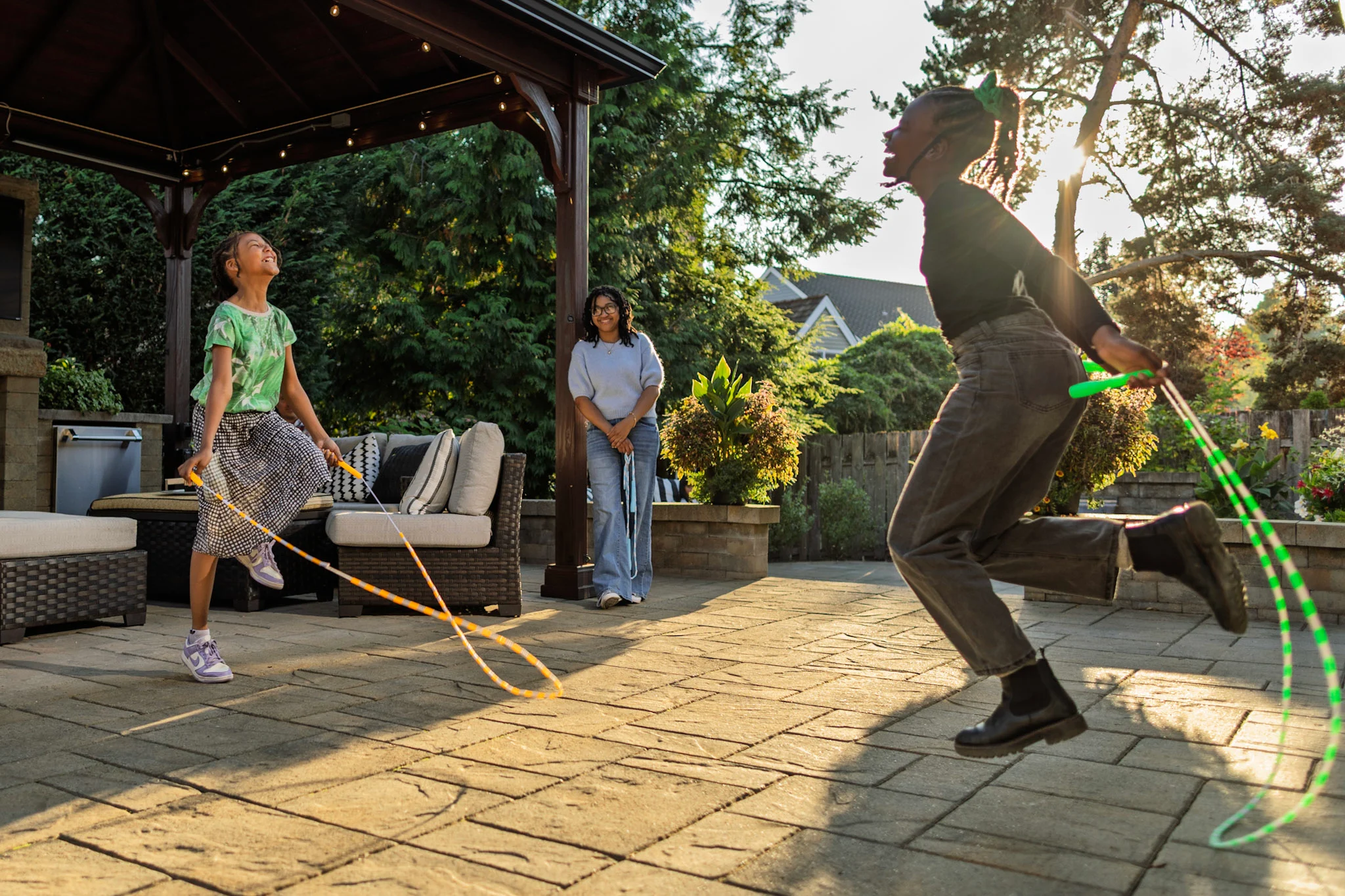 Children playing on paver patio jumping rope and laughing