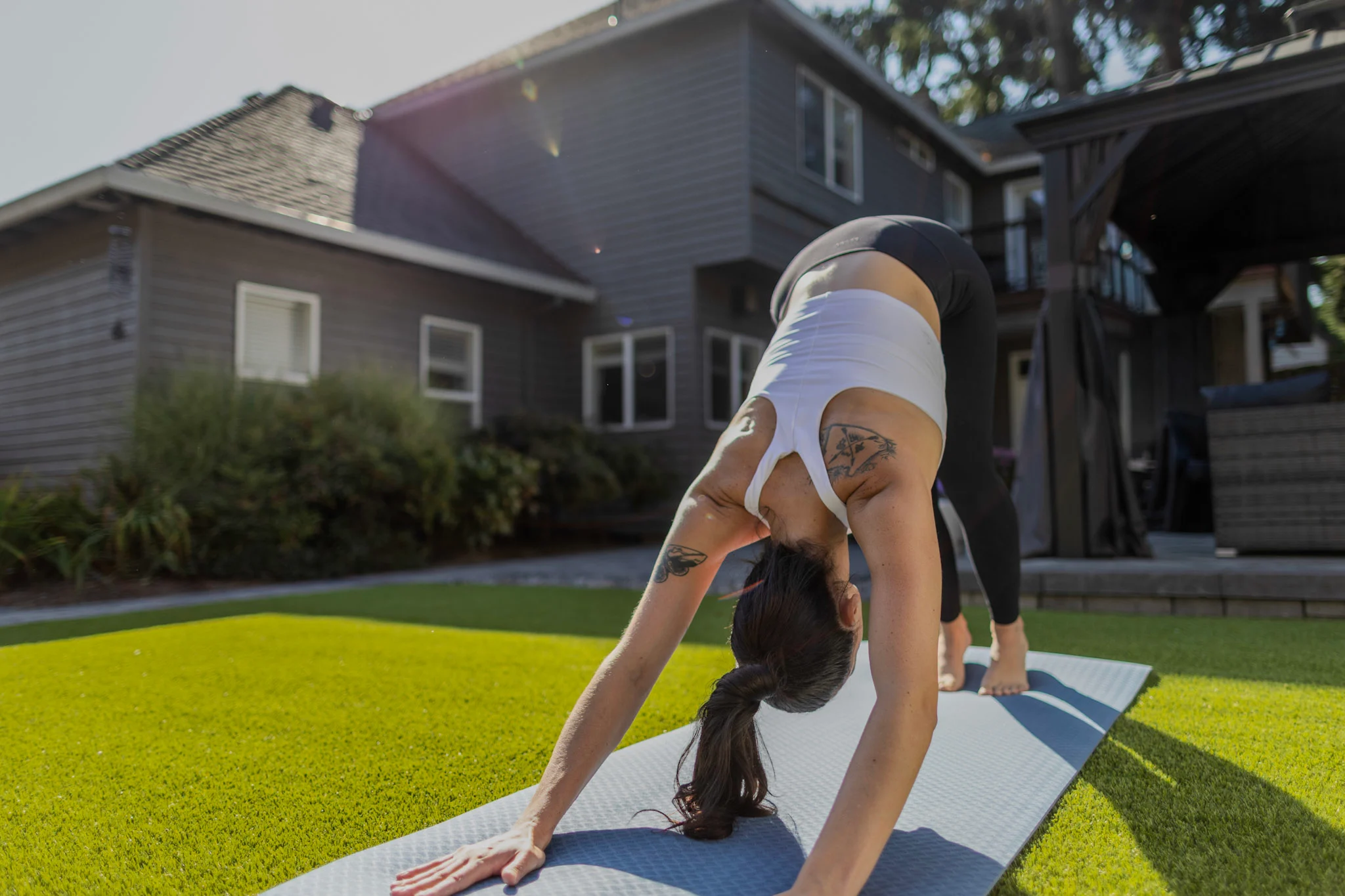 Woman doing yoga outdoors on turf lawn
