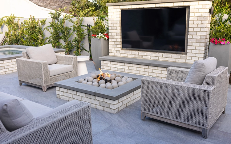 Backyard paver patio with built-in TV and fire pit. 
