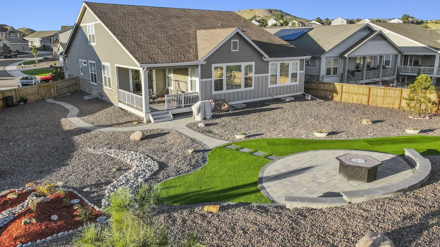 Firepit, sitting walls, walkways, and turf in xeriscape backyard