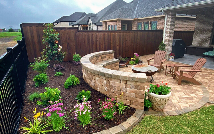 Texas Backyard patio made of paving stones with paving stone retaining wall and landscaping