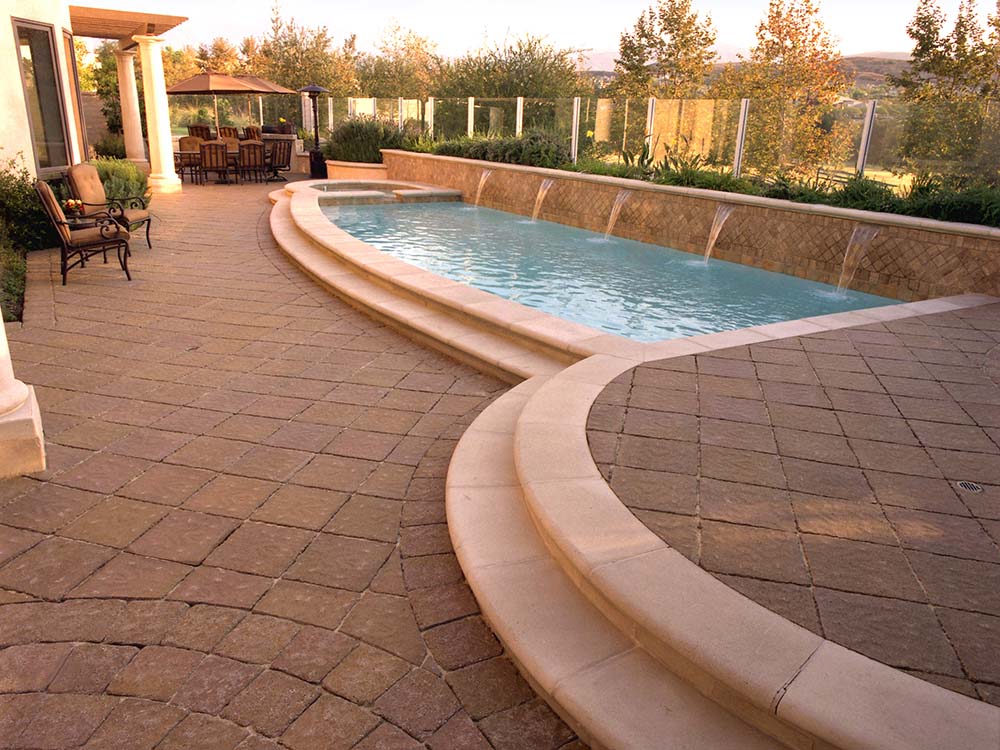 Paver pool deck with paving stone steps, in-ground pool with water features