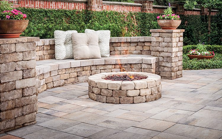 Stove outdoor fireplace on a paver patio with paving stone wall in a Texas yard. 