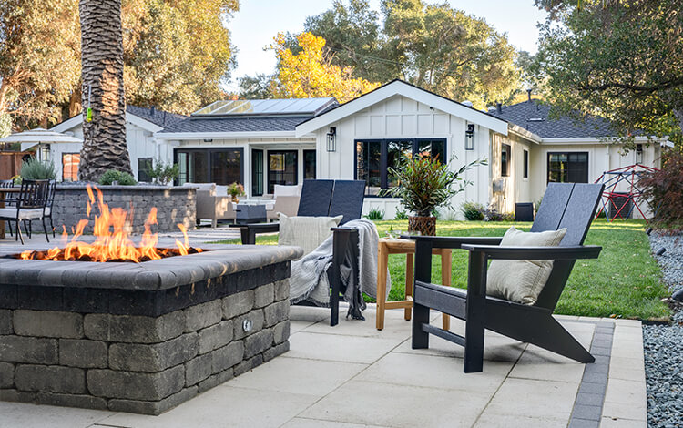 Paving stone patio in a backyard with chairs and tables