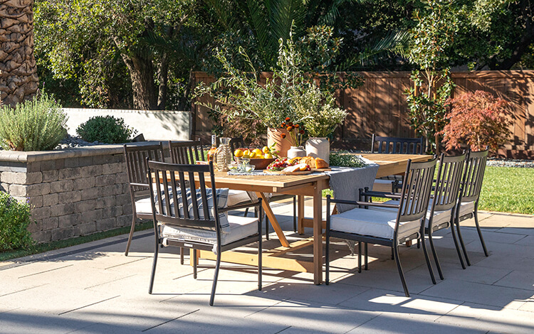 Patio table in a backyard in California made of large gray paving stones