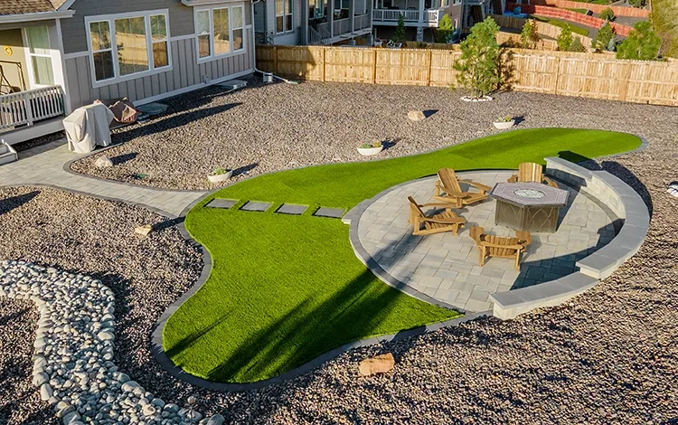 Paver backyard with artificial turf. 