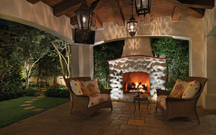 Fire place on a patio with pergola and lighting