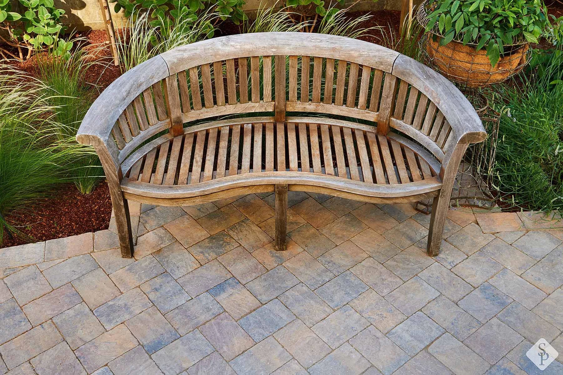 paver walkway with wooden bench