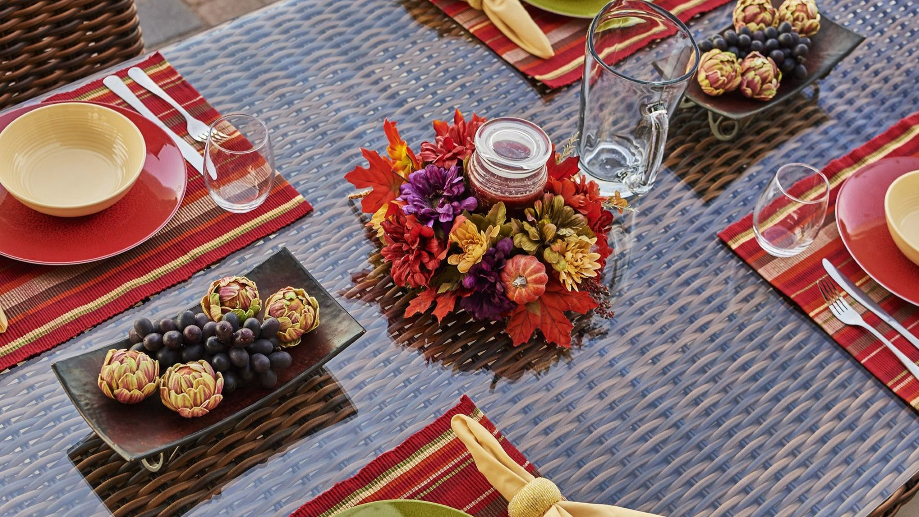 Outdoor dining table set for holiday gathering with fall flowers centerpiece 