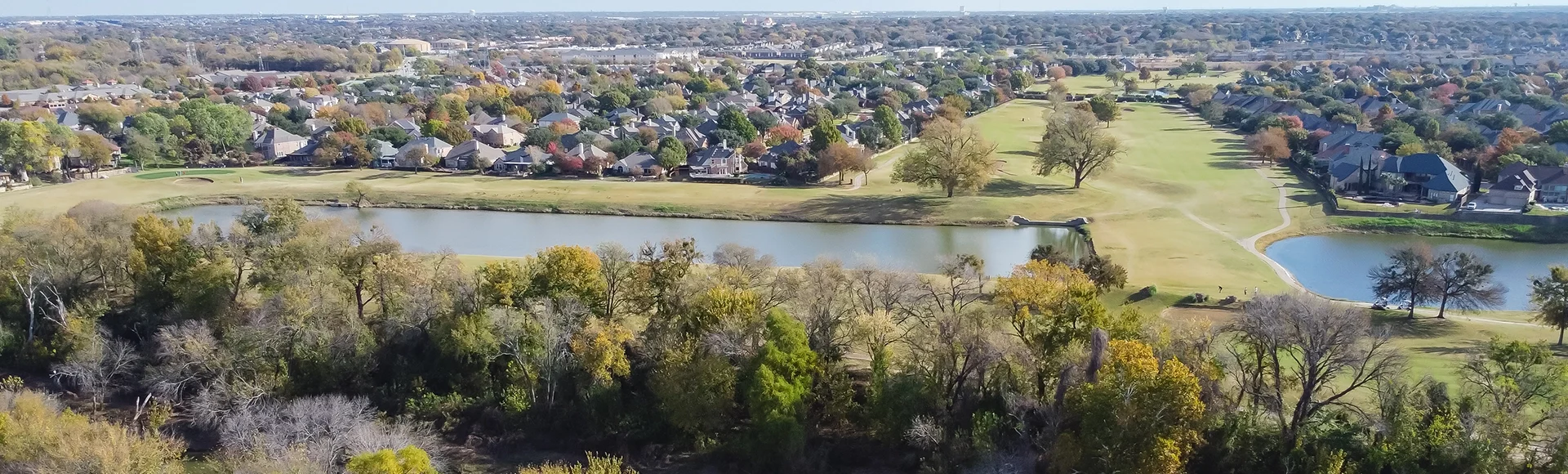 Panoramic top view country club golf course and lakeside residential houses near nature park with fall foliage in Carrollton, Texas, USA