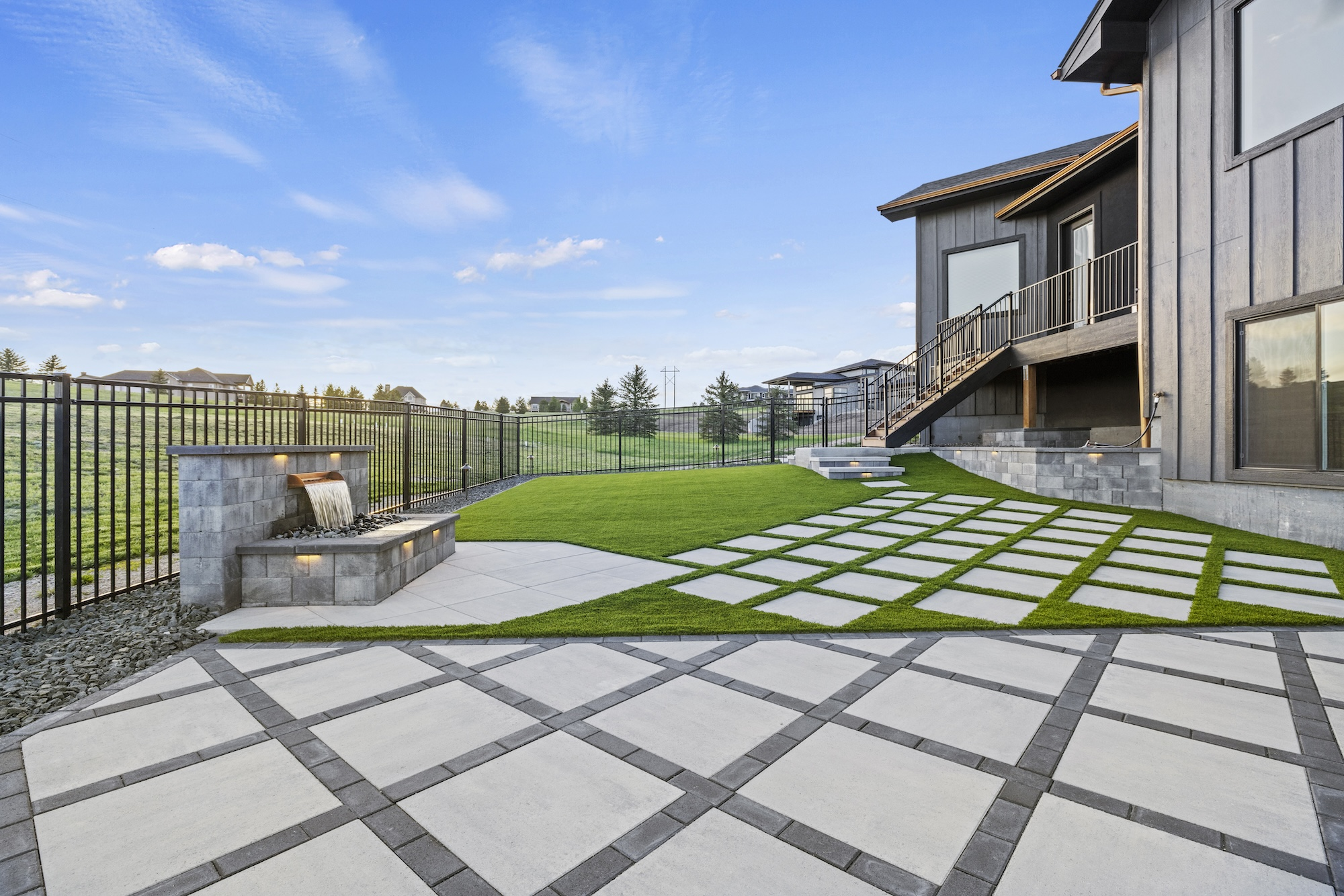 Denver Colorado permeable paver backyard with artificial turf and water feature