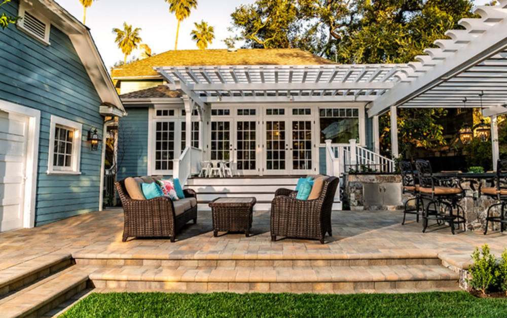 pretty backyard with paving stone patio, pergola, deck and outdoor entertainment and dining area