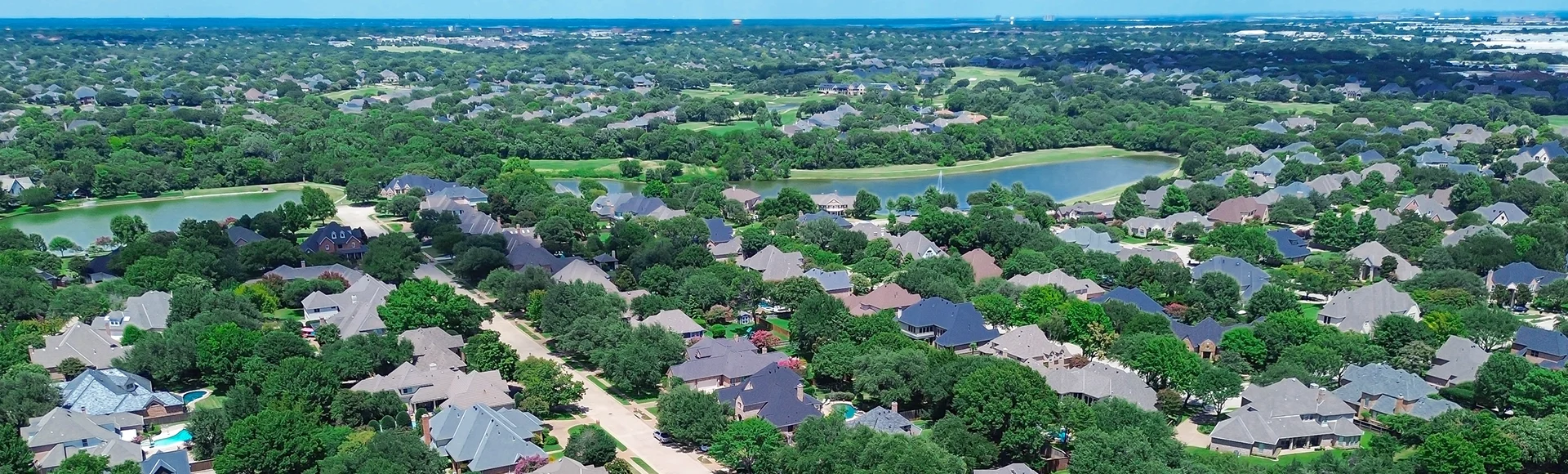 Dual scenic ponds with water fountain in upscale neighborhood in Colleyville, Texas, dense residential layout with tree-lined streets, landscaped yards, and large two-story homes, suburbs Dallas