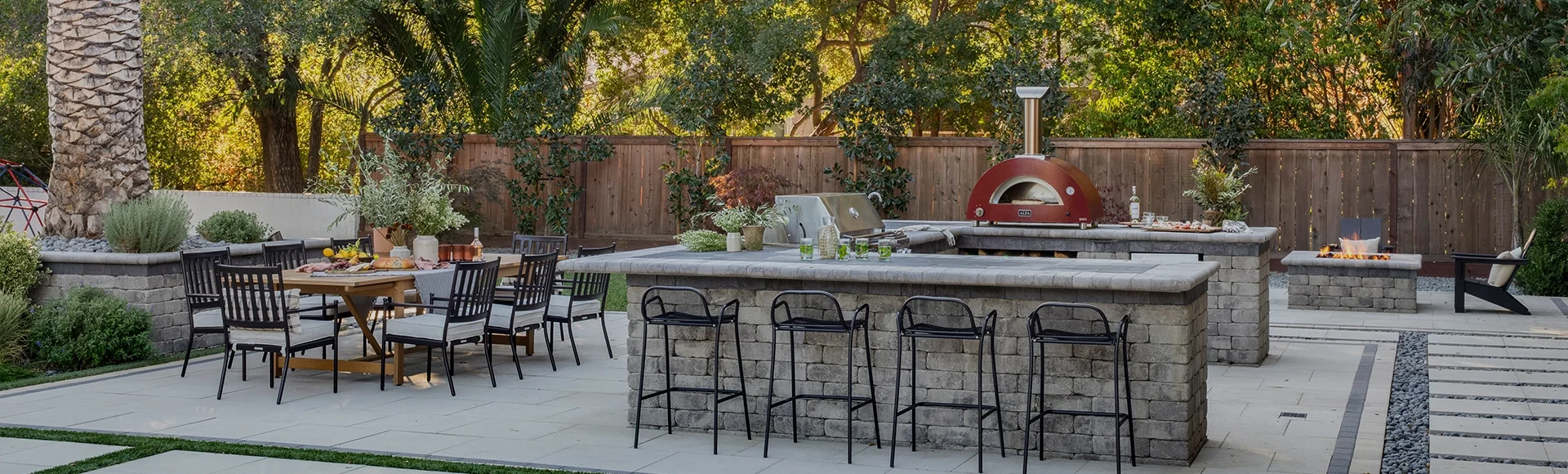 Outdoor kitchen built by System Pavers on a paver patio with built-in fire pit. 