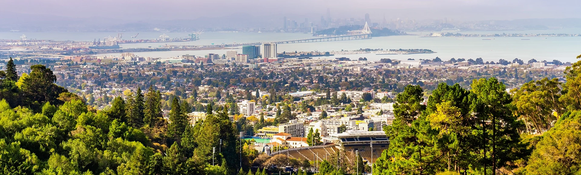 Panoramic view of Berkeley; San Francisco Bay shoreline with Port of Oakland, Yerba Buena Island, Treasure Island, the Bay bridge and the San Francisco skyline visible in the background; California