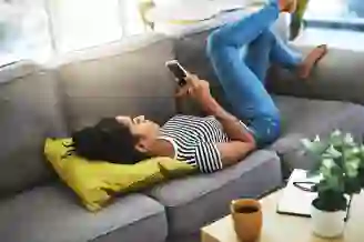 Woman laying on sofa with phone