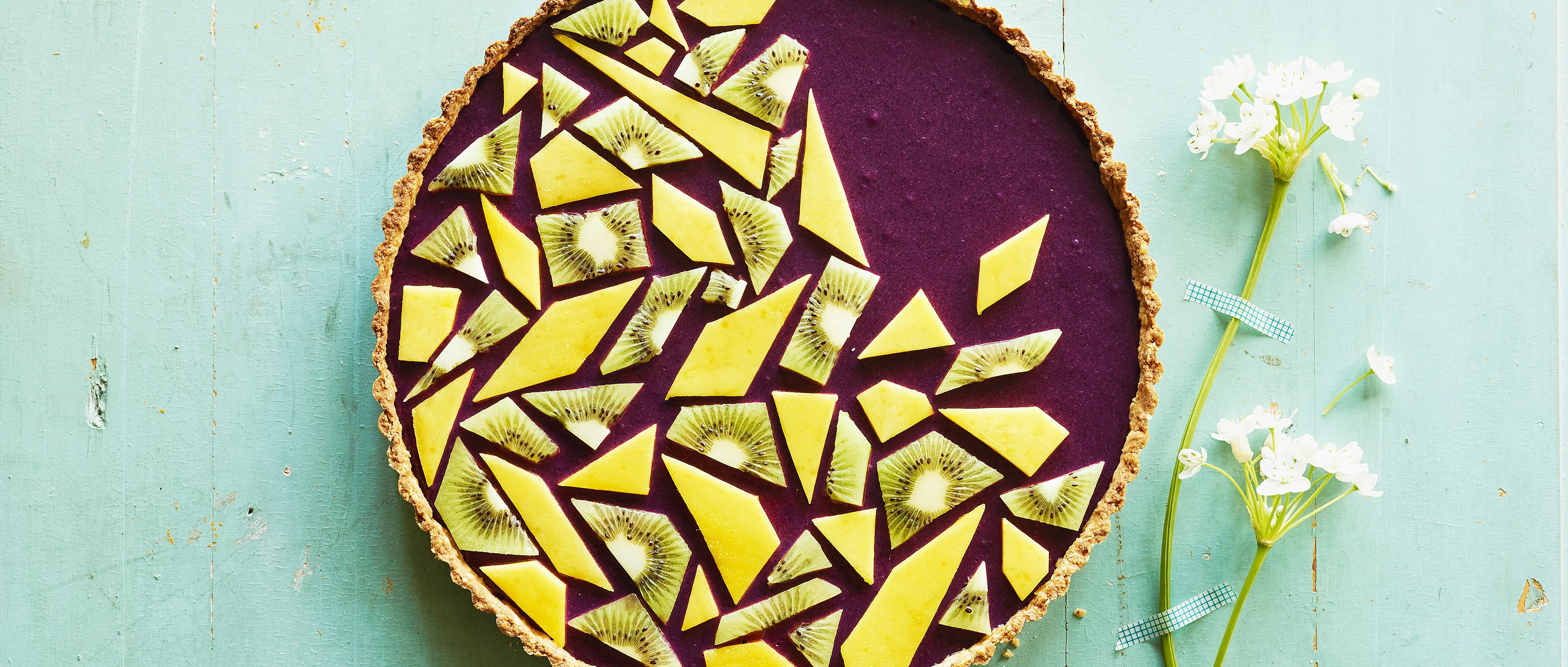 Heidelbeertarte mit Mango und Kiwi dekoriert