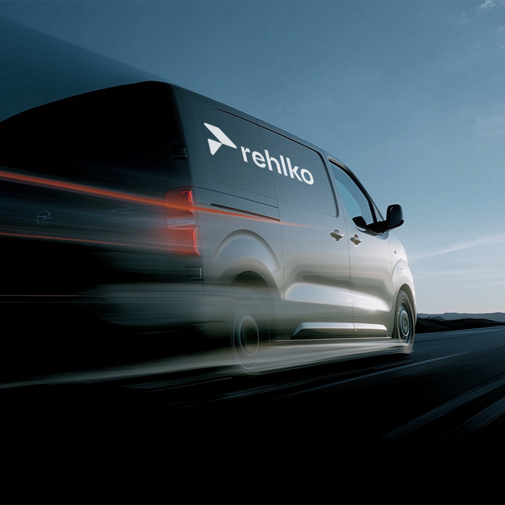 A fast-moving car with Rehlko logo leaving a trail of lights