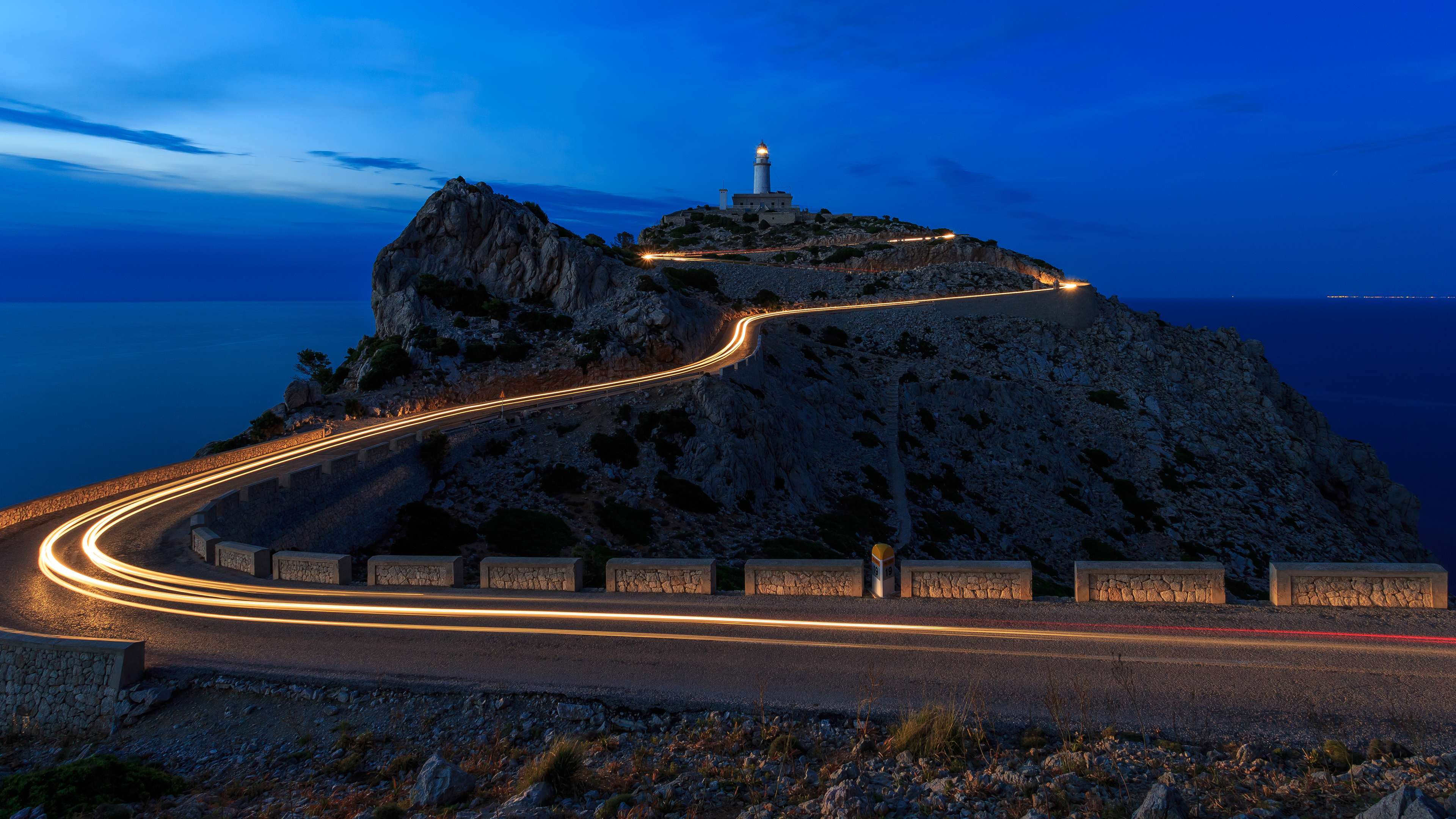 Lighthouse shown at night with road leading up to it