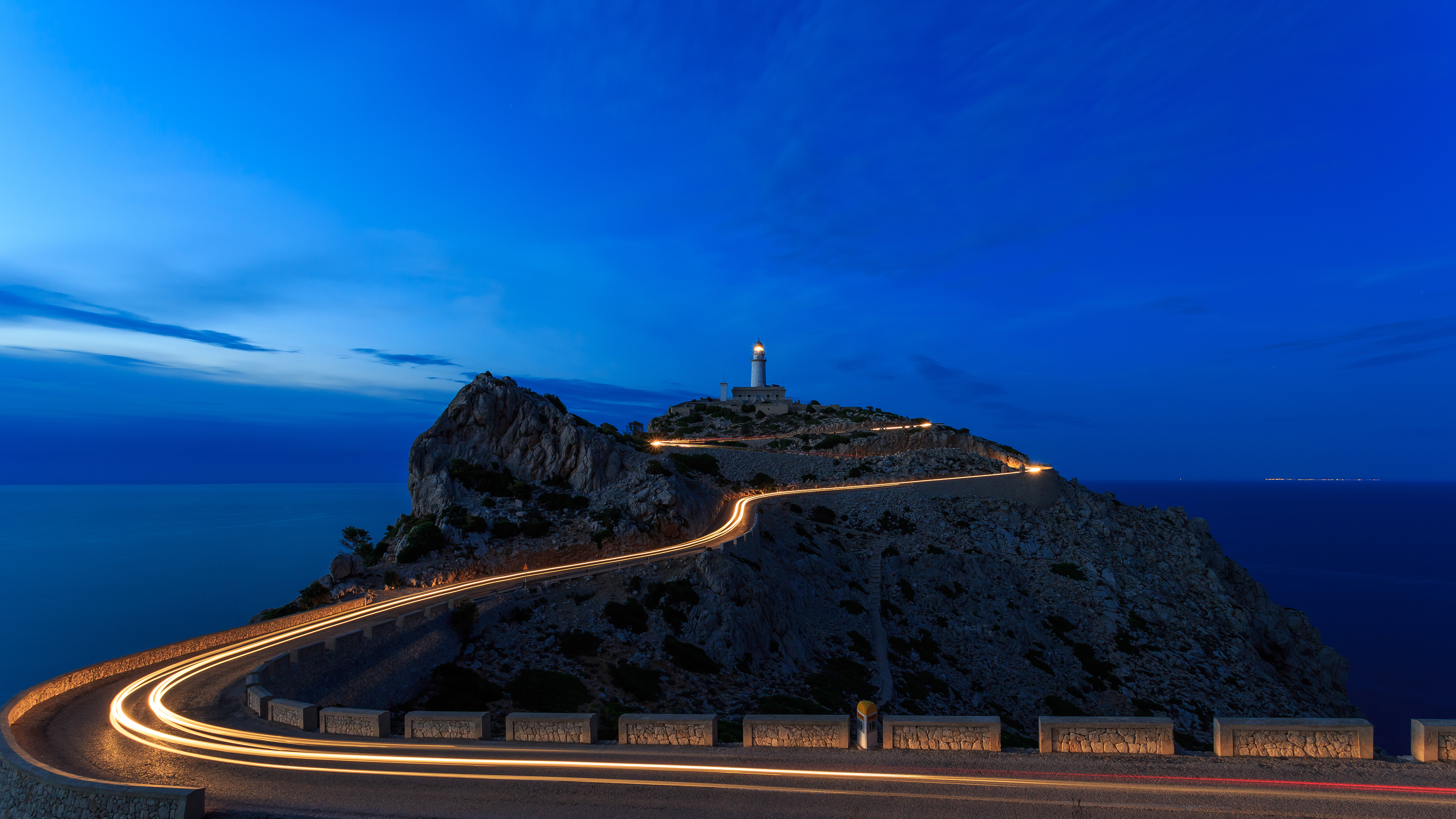 Lighthouse shown at night with road leading up to it