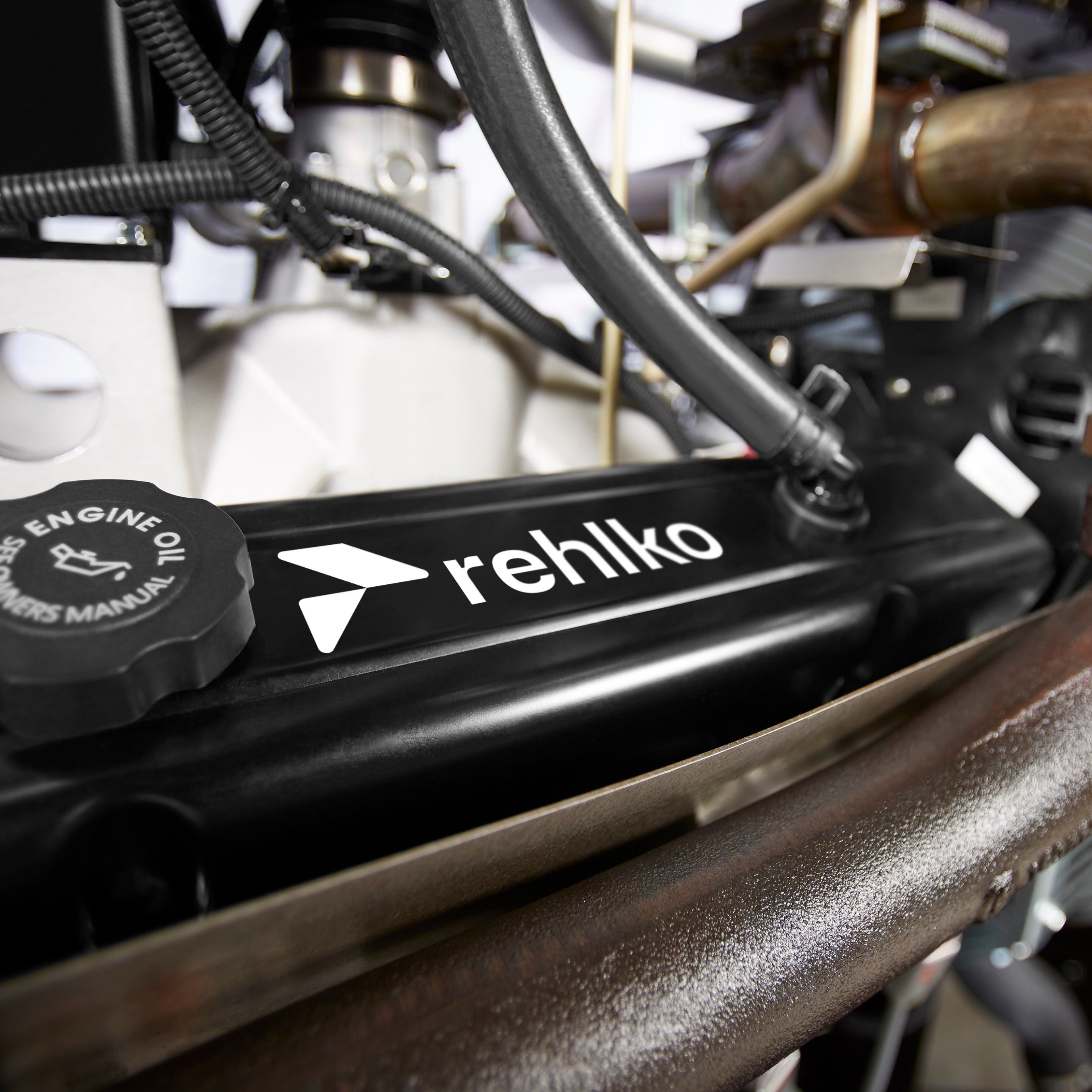 Zoomed-in view of an engine with a dense arrangement of cables and pipes, highlighting the Rehlko logo prominently displayed on a component.