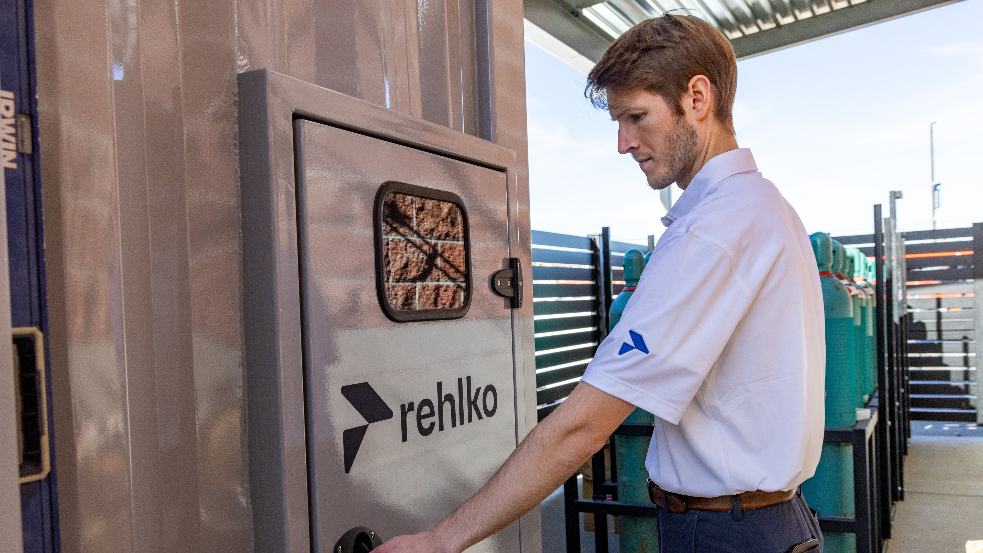 Rehlko employee in front of a panel door