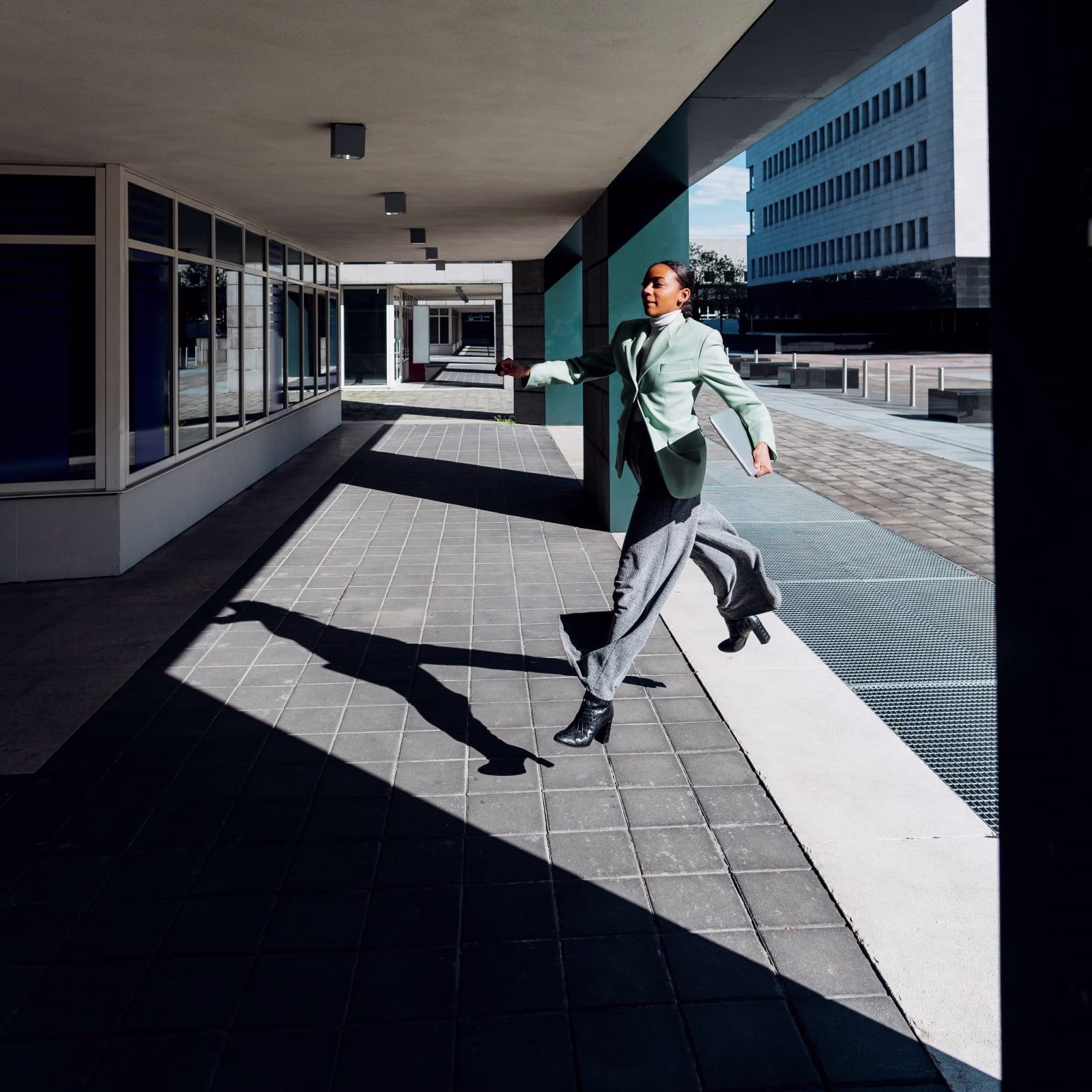 Woman in business clothing running to enter a building.