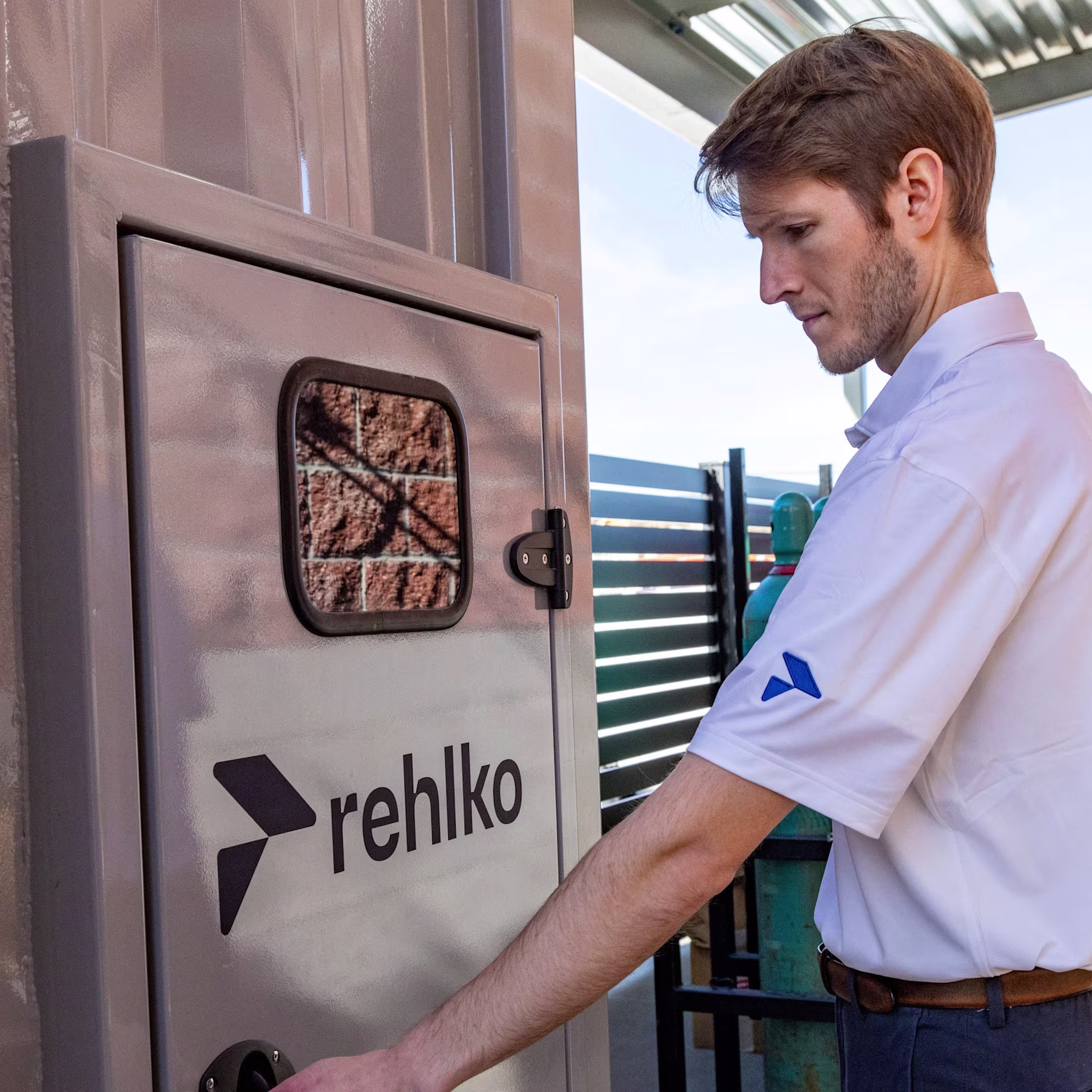 Rehlko employee in front of a panel door