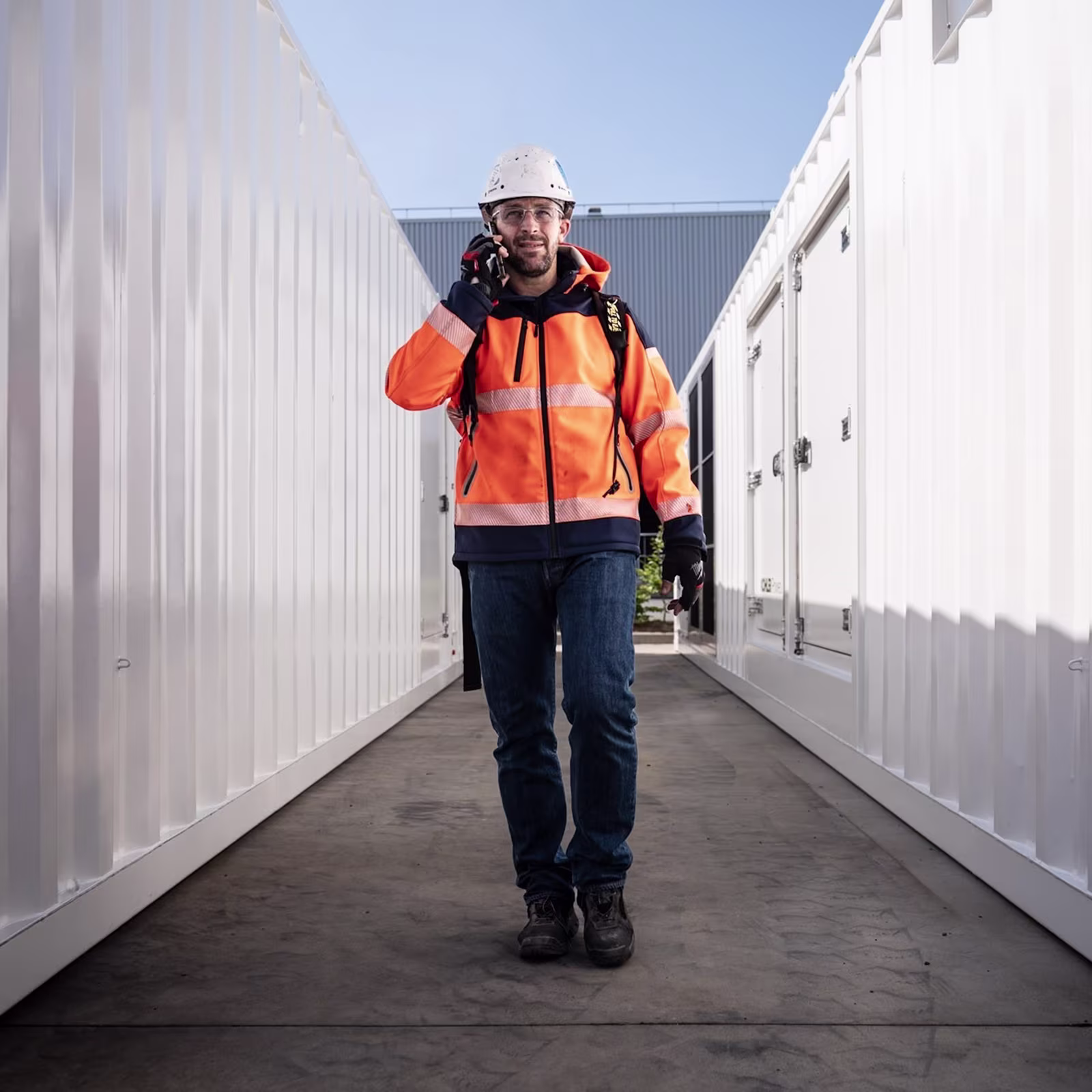 Worker walking between generators talking on a cellphone