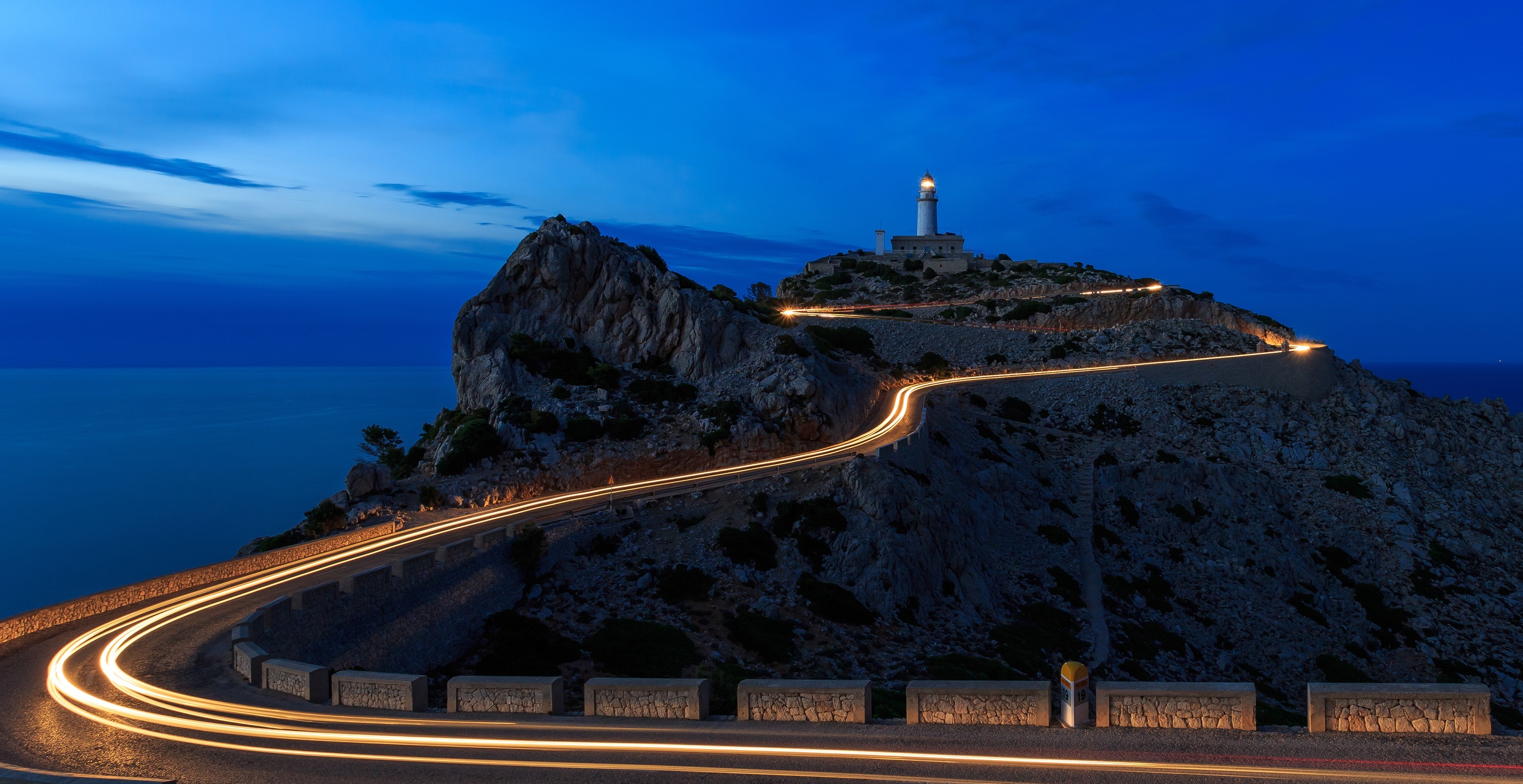 Lighthouse shown at night with road leading up to it